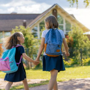 Deux sœurs marchant vers l'école avec leurs cartables