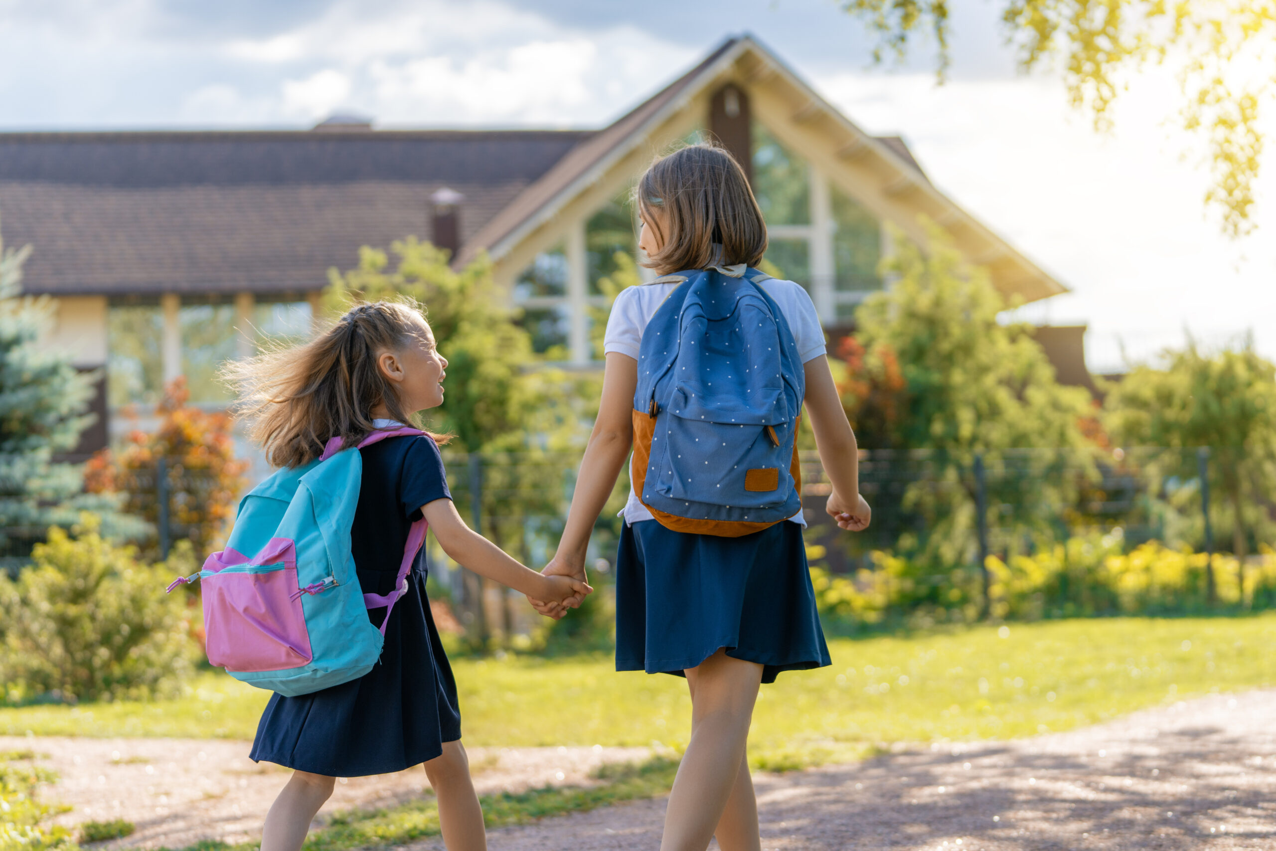 Deux sœurs marchant vers l'école avec leurs cartables